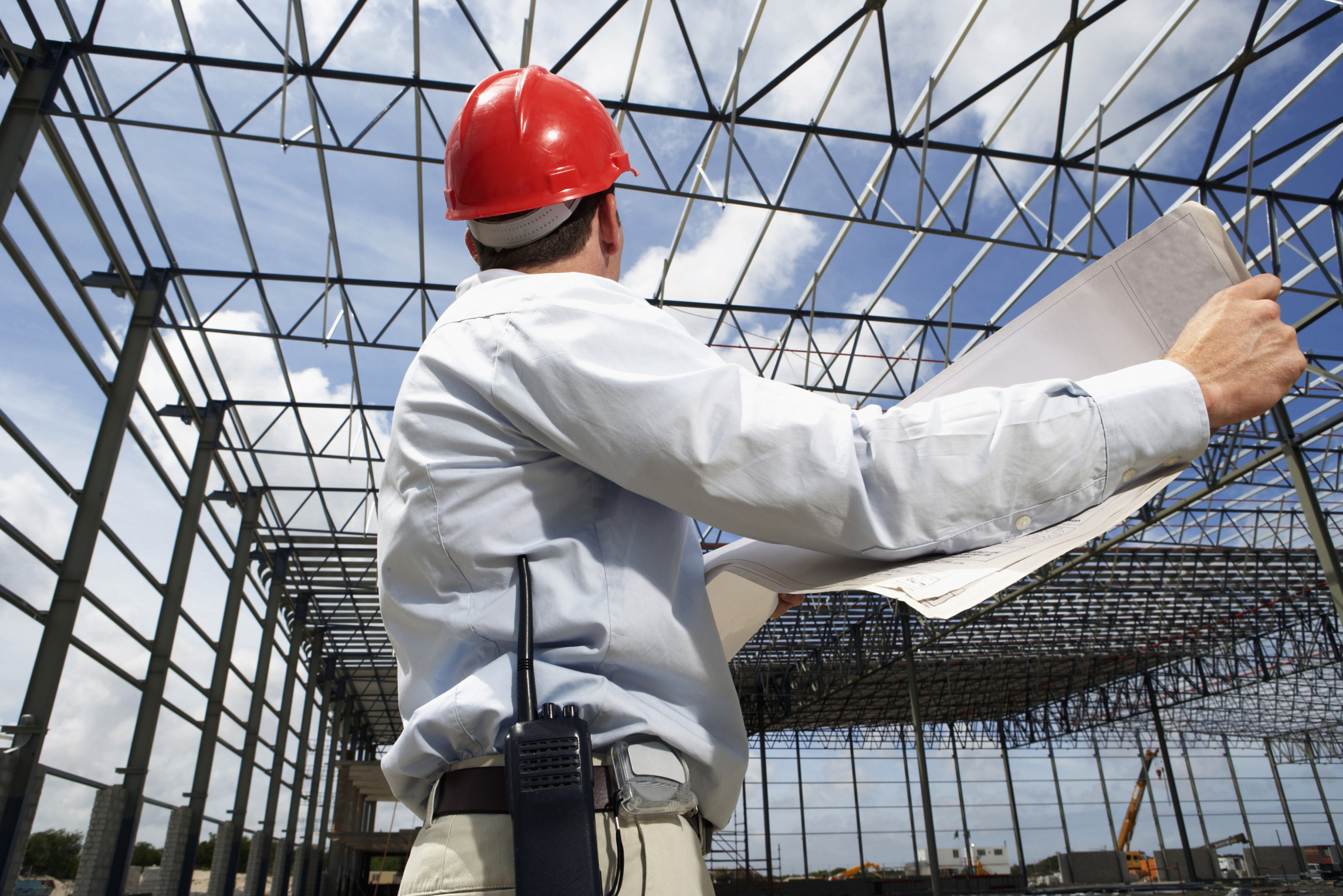 Construction Worker Holding Plans on Building Site